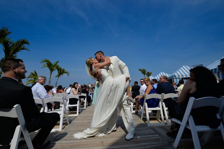 Bride and groom sharing a kiss during their wedding ceremony at Crescent Beach Club.