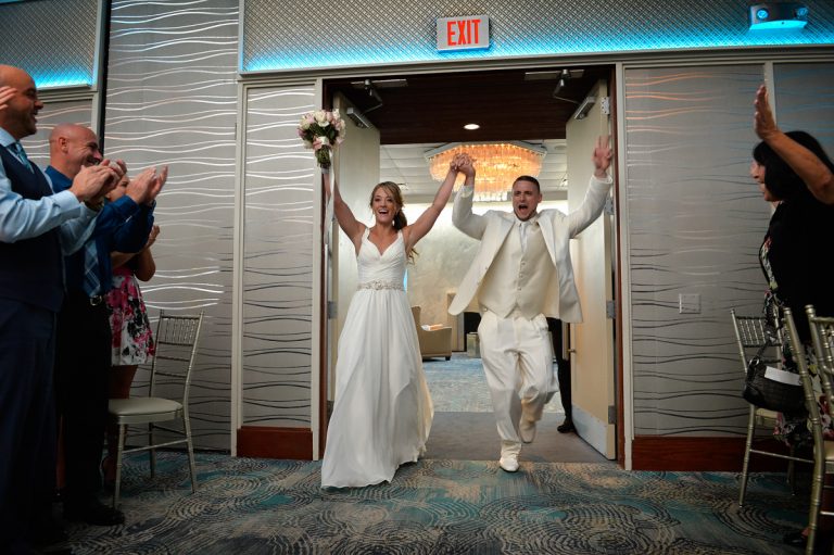 Bride and groom joyfully entering the reception area, celebrating their wedding day.