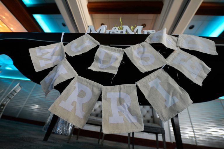 Fabric banner displaying 'Mr & Mrs' at a wedding reception table.