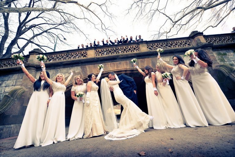 Bridal party posing in Central Park with bouquets, celebrating a wedding moment.