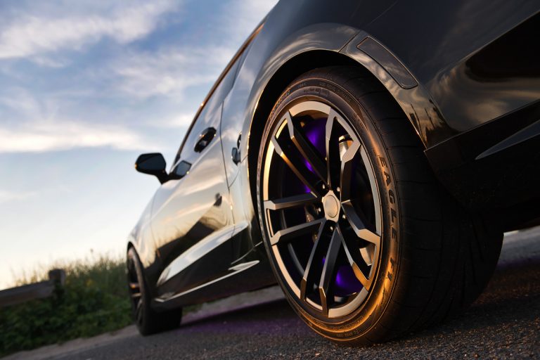 Close-up view of a black car showcasing its stylish wheels and tire details.