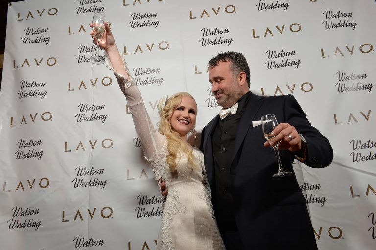 Bride and groom raising glasses in celebration at a wedding event at Lavo.